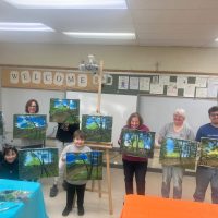 Kevin Wolff and students showcasing their oil paintings in class